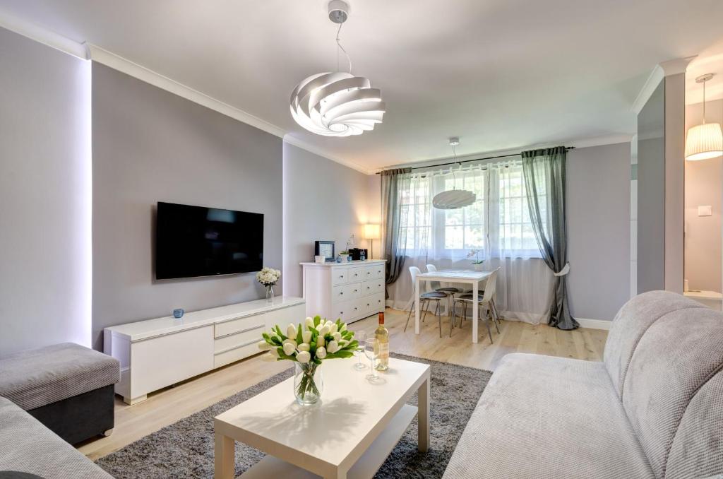 a living room with a couch and a tv at Dom & House - Apartments Karlikowska Sopot in Sopot