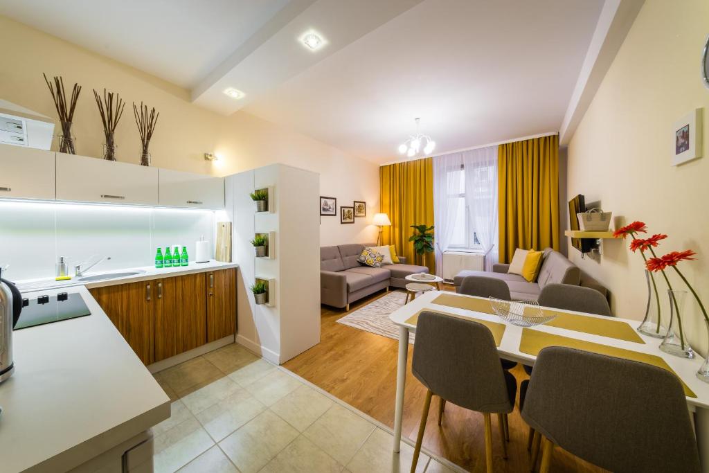 a kitchen and living room with a table and chairs at Apartament Wietora WAWELOFTS in Krakow