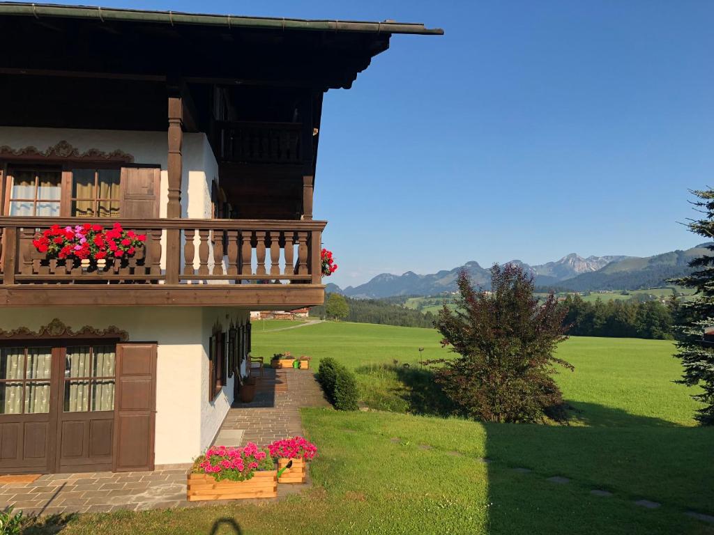 ein Haus mit einem Balkon mit Blumen darauf in der Unterkunft Panoramaresidenz Blindau in Reit im Winkl