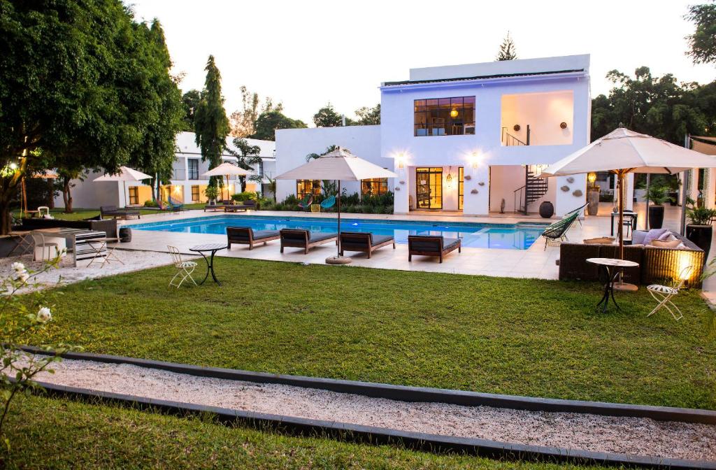 a villa with a swimming pool and a house at Latitude 13 Degrees in Lilongwe