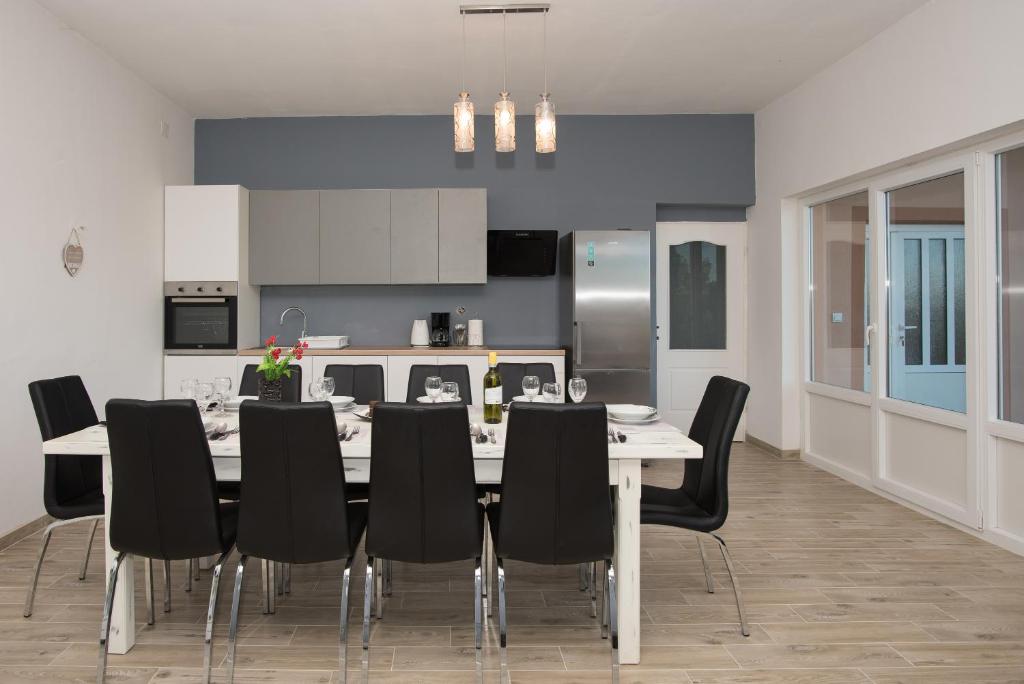 uma cozinha e sala de jantar com mesa e cadeiras em Apartman Stipe em Gaćelezi