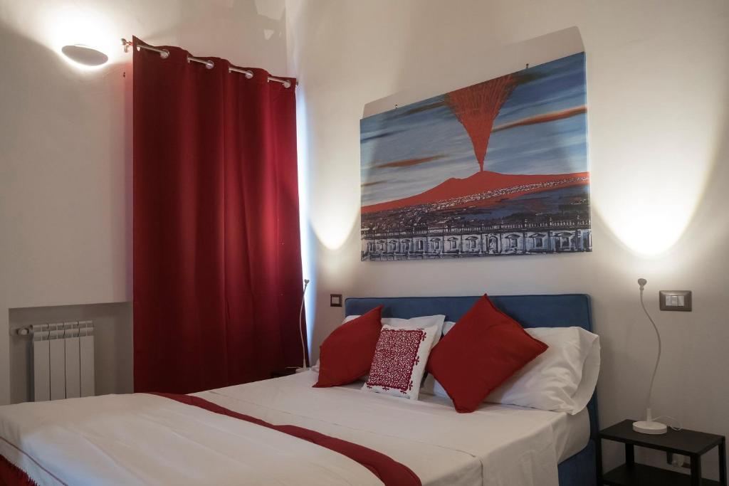 ナポリにあるLa Pazziella Flatのベッドルーム1室(赤いカーテン付きのベッド1台付)