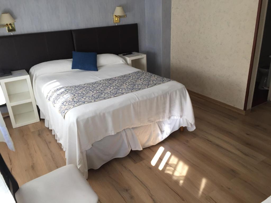 1 dormitorio con cama grande y almohada azul en San Marco Hotel, en La Plata