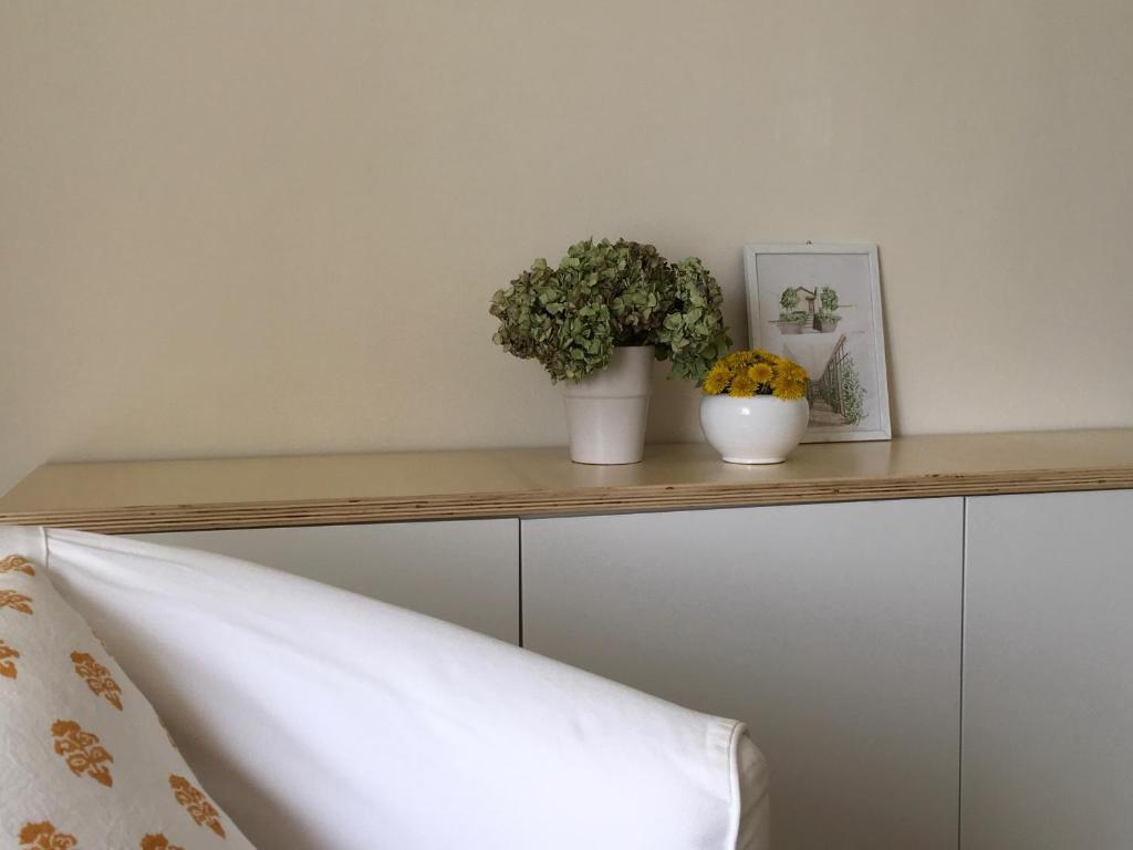 uma prateleira de madeira com duas plantas em cima de uma cama em HOUSE&GARDEN em San Donato Milanese