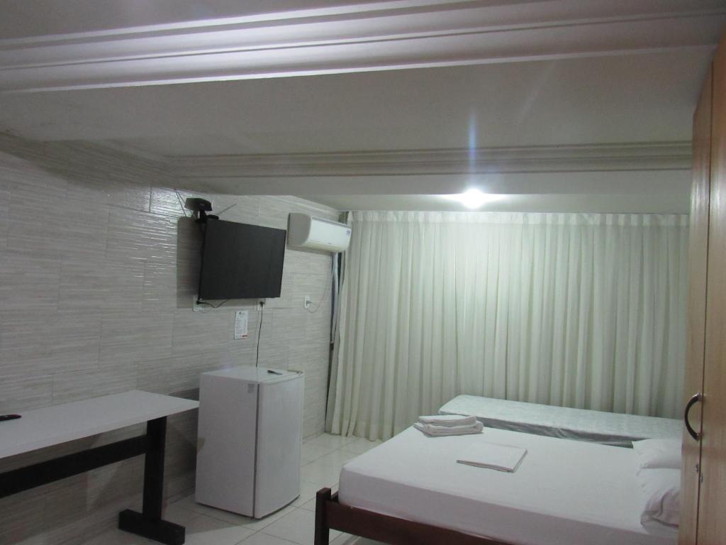 a small room with a bed and a small table at River Class Hotel in Petrolina