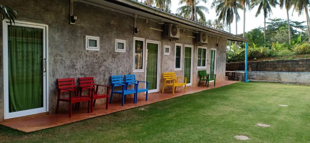 a group of colorful chairs sitting on a porch at Koh Mak Homestay in Ko Mak