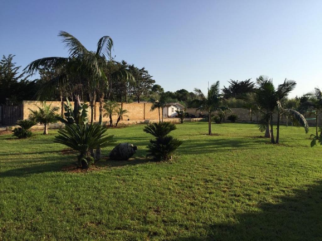 a park with palm trees and a field of grass at Petruso Resort in Balestrate