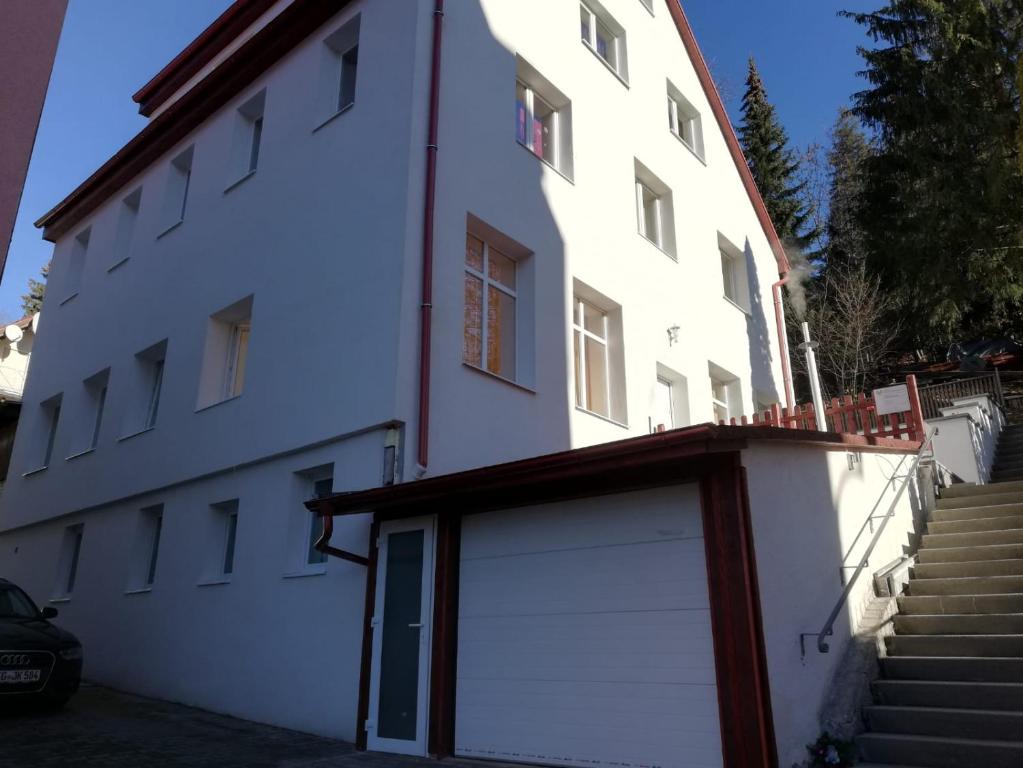a white building with a garage in front of it at Ferienwohnungen Albstadt in Albstadt