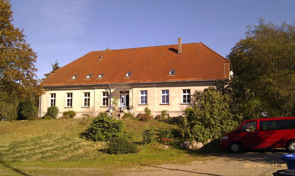 un coche rojo estacionado frente a una casa en Gutshaus Alt-Jargenow en Alt Jargenow