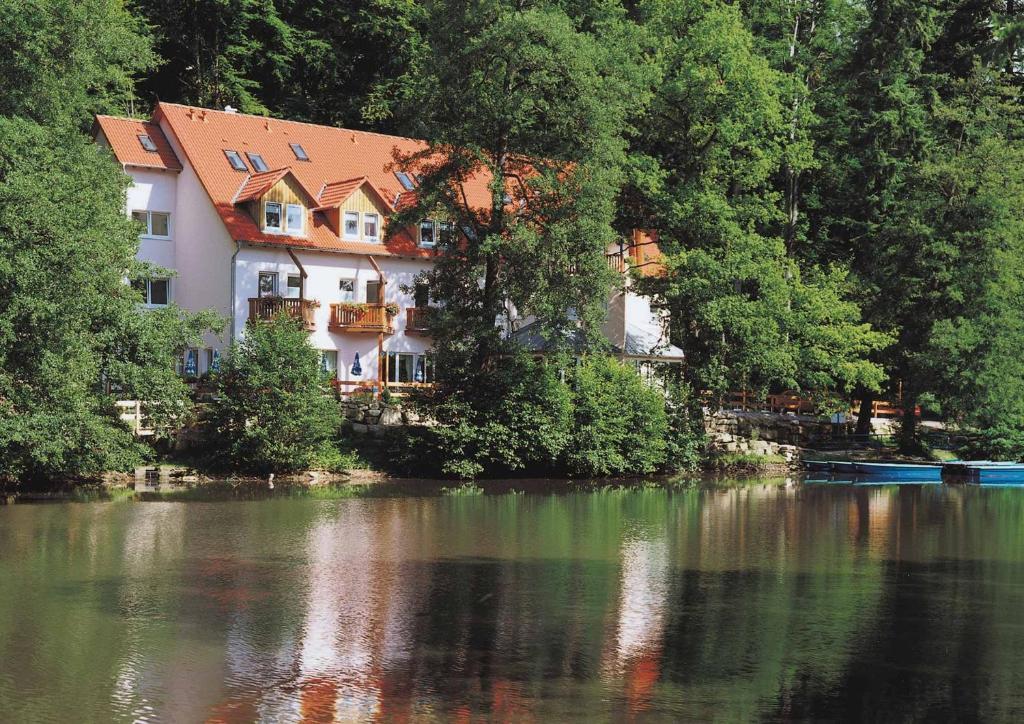 a building on the side of a river at WAGNERS Seehotel Schleusingen in Schleusingen