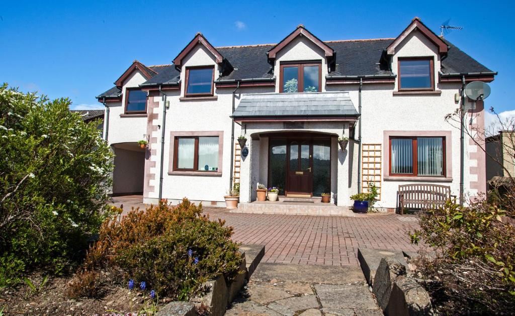 een groot wit huis met een stenen oprit bij Dunhallin House in Inverness