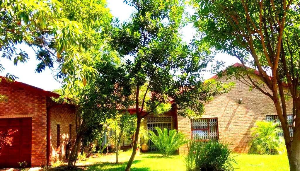 a brick house with trees in front of it at Ankuweni Guest house in Giyani