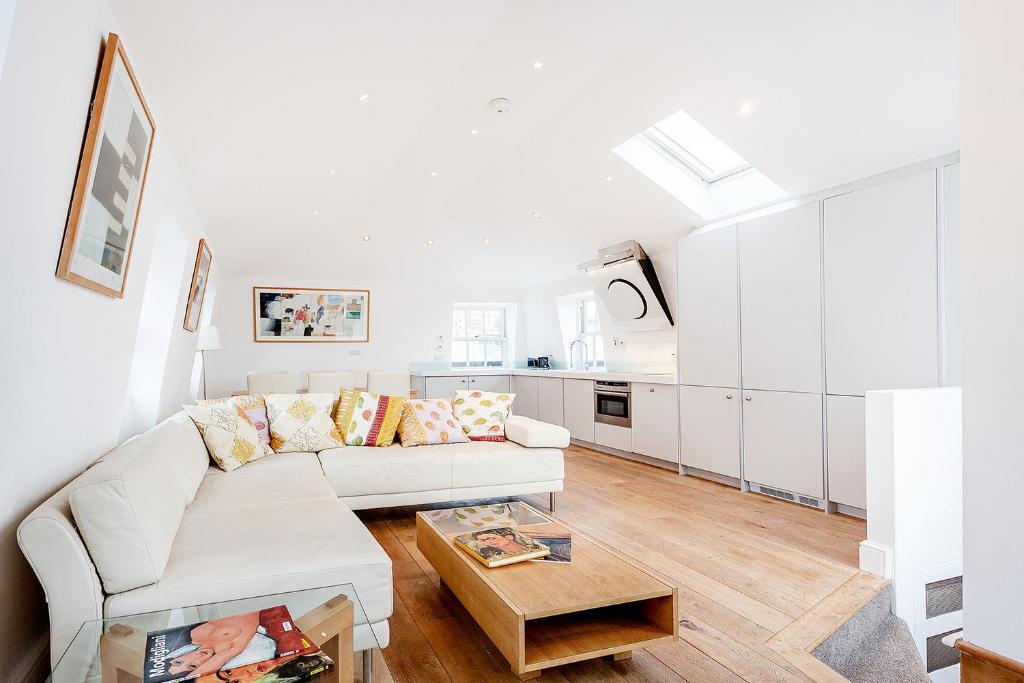 uma sala de estar branca com um sofá e uma mesa em Beautiful 2 bedrooms apartment in Knightsbridge em Londres