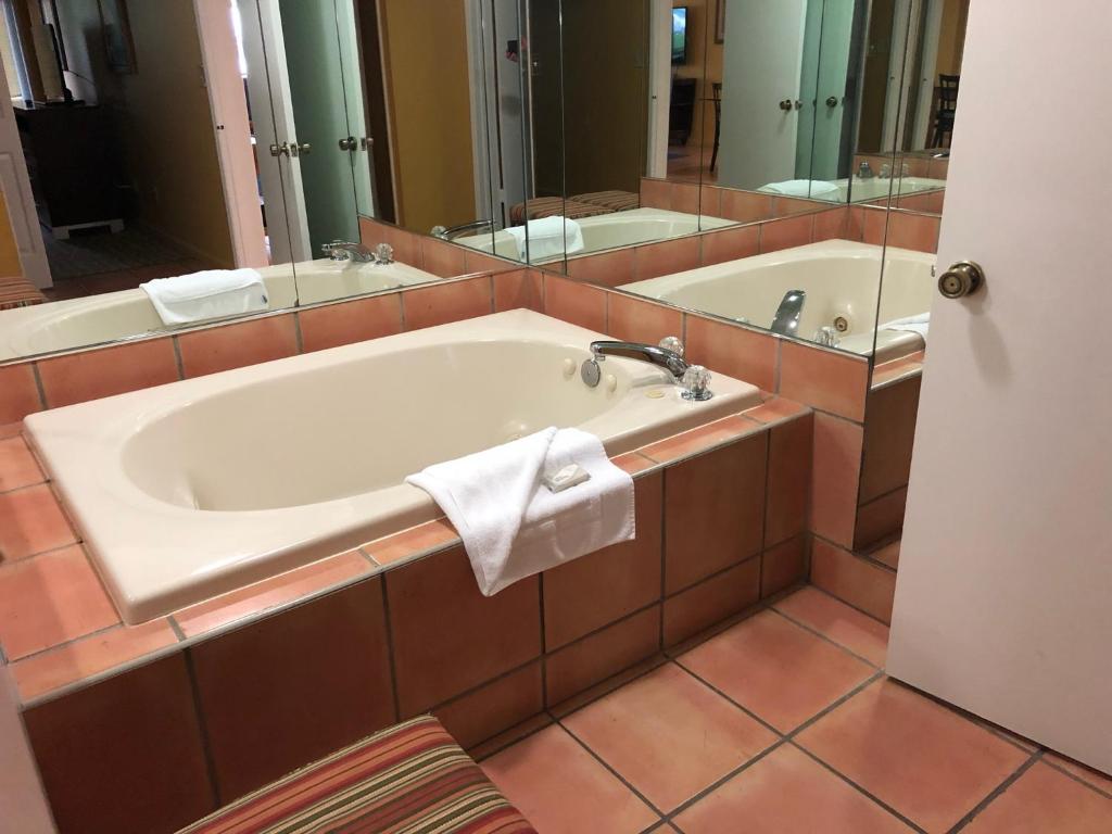 a bathroom with a bath tub and a mirror at Vacation Village at Bonaventure in Weston