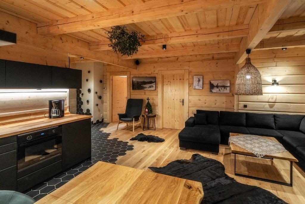 a living room with a black couch and a table at ZAKOPIANA in Zakopane