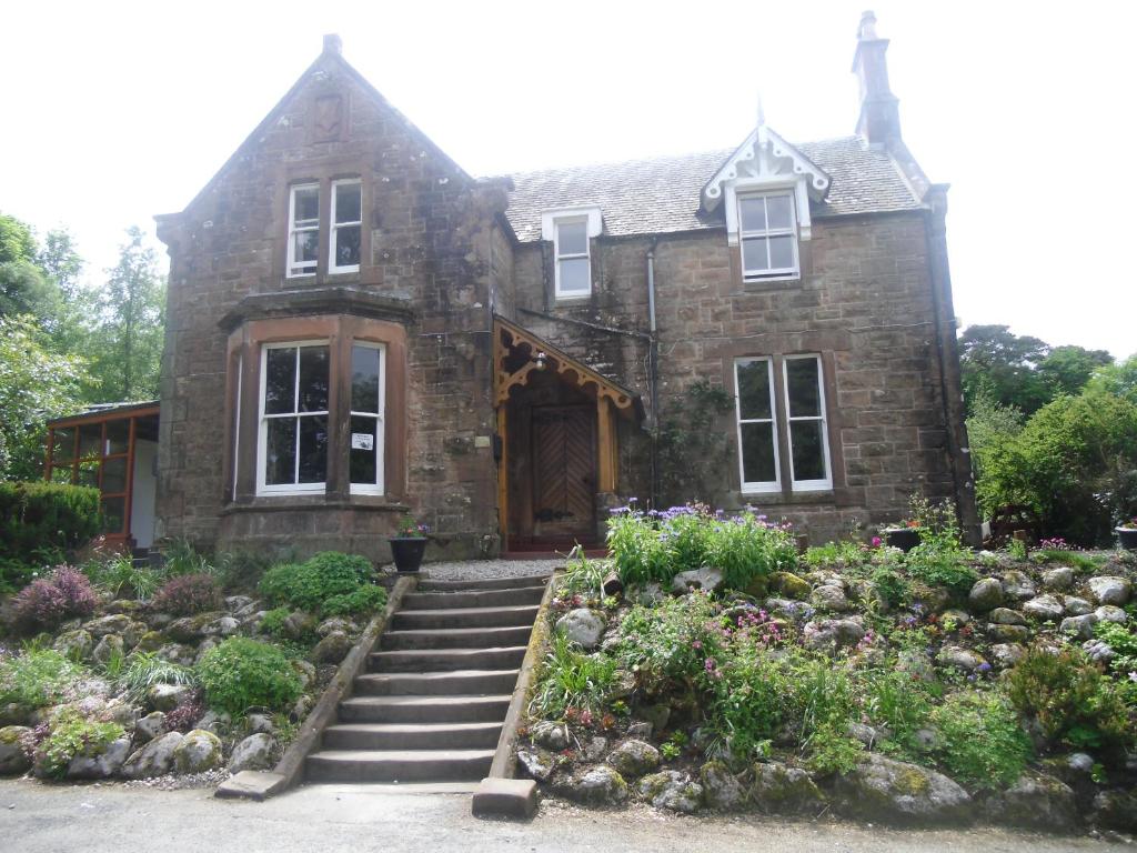 una vecchia casa in pietra con un giardino di fronte di Ormidale Hotel a Brodick