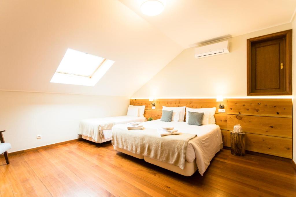 a bedroom with two beds and a skylight at Ericeira Soul Guesthouse in Ericeira