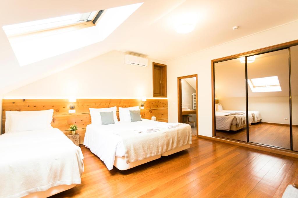 a bedroom with two beds and a large mirror at Ericeira Soul Guesthouse in Ericeira