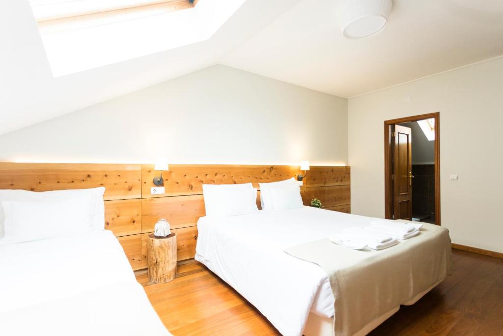 a bedroom with a large white bed and a window at Ericeira Soul Guesthouse in Ericeira