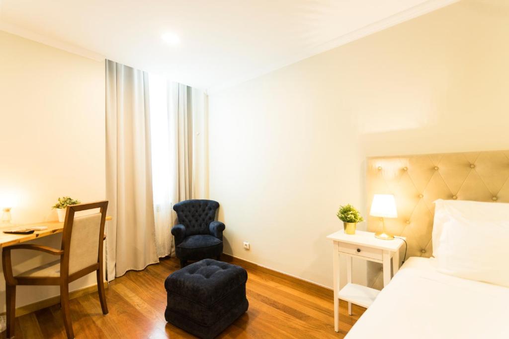 a bedroom with a bed and a desk and a chair at Ericeira Soul Guesthouse in Ericeira