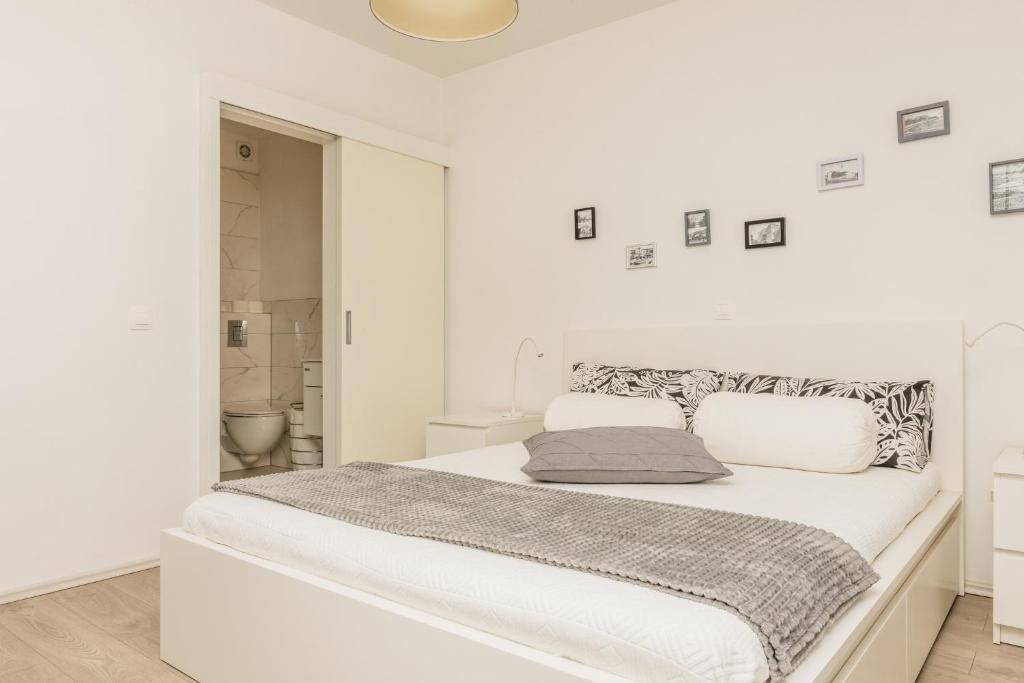 a white bedroom with a large white bed with two pillows at Acapella soba in Crikvenica