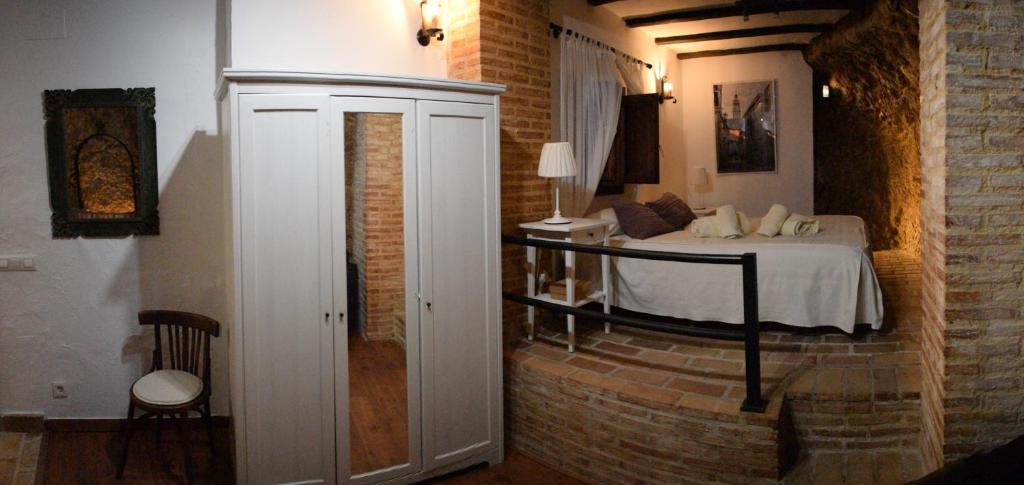 sypialnia z łóżkiem w ceglanej ścianie w obiekcie Casa Cueva El Pocito w mieście Peñaflor