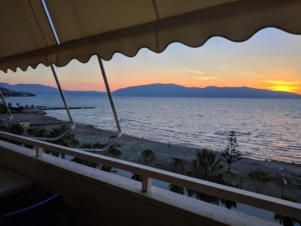 uma vista para o oceano ao pôr-do-sol a partir de uma varanda em Lucky Lux Apartment em Vlorë