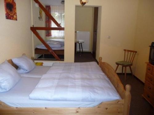 een slaapkamer met een groot bed met witte lakens bij Gasthof Postkutsche in Motten