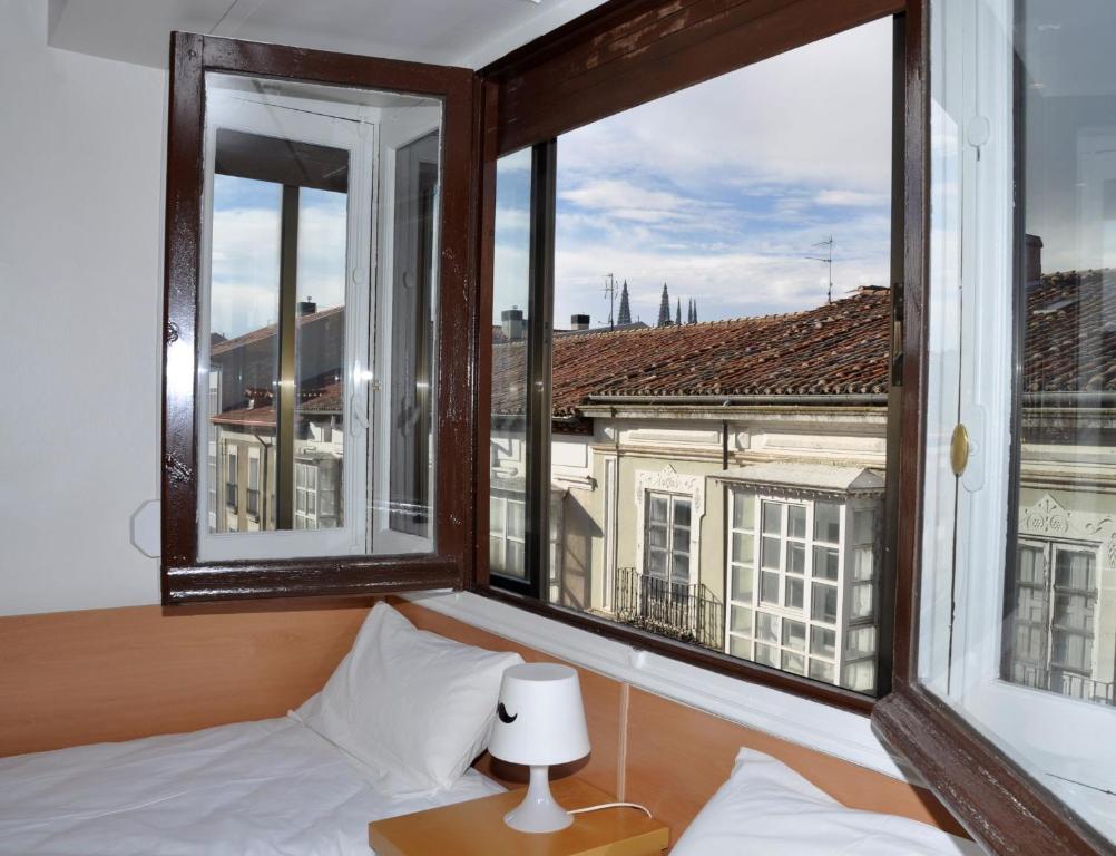 - une chambre avec un lit et une fenêtre avec vue dans l'établissement VillaDel Casa Urbana, à Burgos