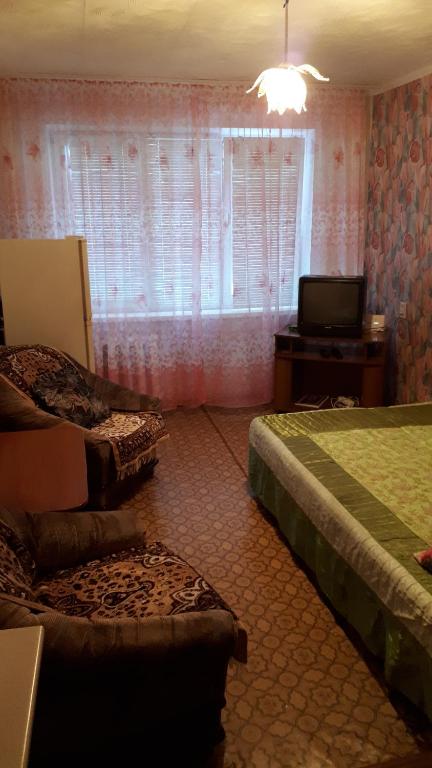 ケメロヴォにあるApartment on Stroiteley 19のベッドルーム1室(ベッド2台、テレビ、窓付)