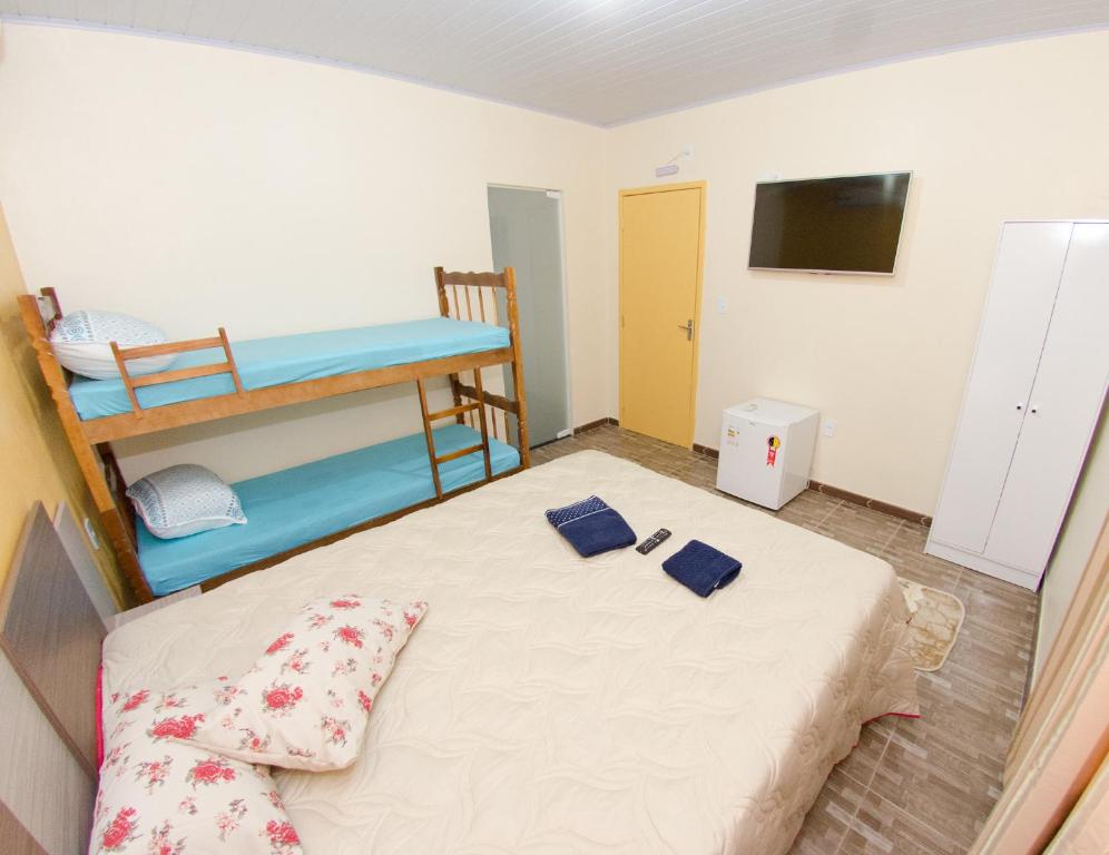 Habitación pequeña con 1 cama y 1 litera en Pousada Família Cordeiro, en Penha