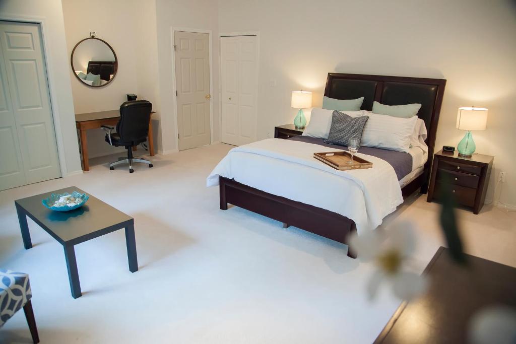 a bedroom with a bed and a desk and a chair at The Inlet Bed & Breakfast in Saanichton
