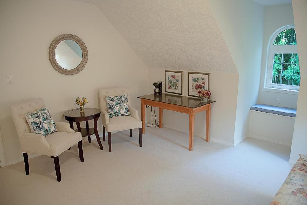 a room with a table and chairs and a mirror at The Inlet Bed & Breakfast in Saanichton