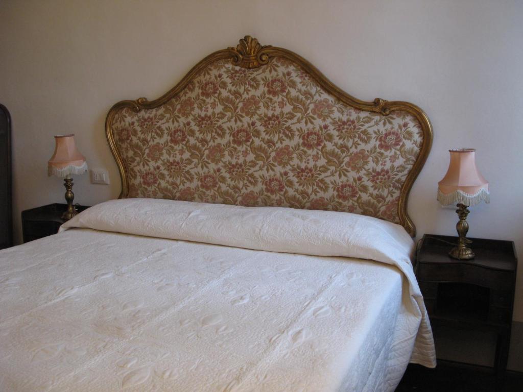 een slaapkamer met een bed met een hoofdeinde en 2 lampen bij L'Albero di Garibaldi in Florence