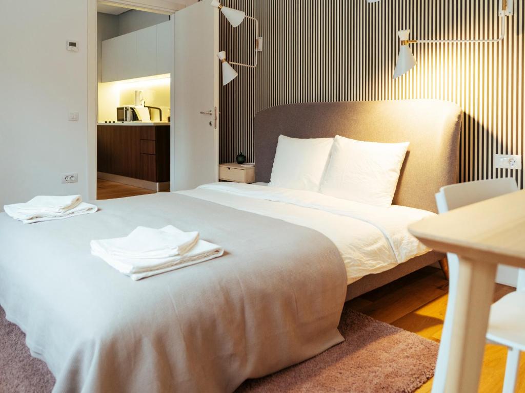 een slaapkamer met een groot bed en handdoeken bij Boutique Luxury Flats - La Maison du Petit Paris in Boekarest