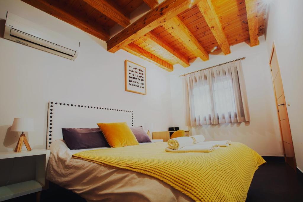 um quarto com uma cama grande e um cobertor amarelo em Dúplex en la Judería de Toledo em Toledo