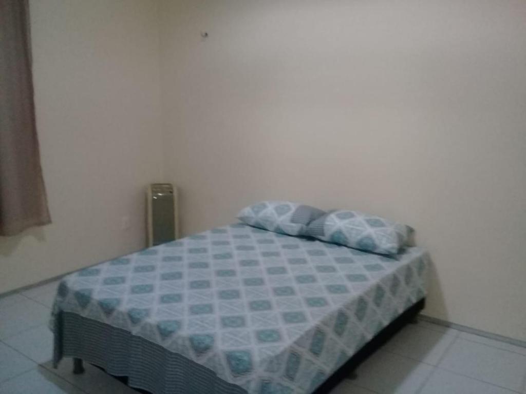 a bedroom with a bed with a blue comforter at Casa Praia Luís Correia in Luis Correia