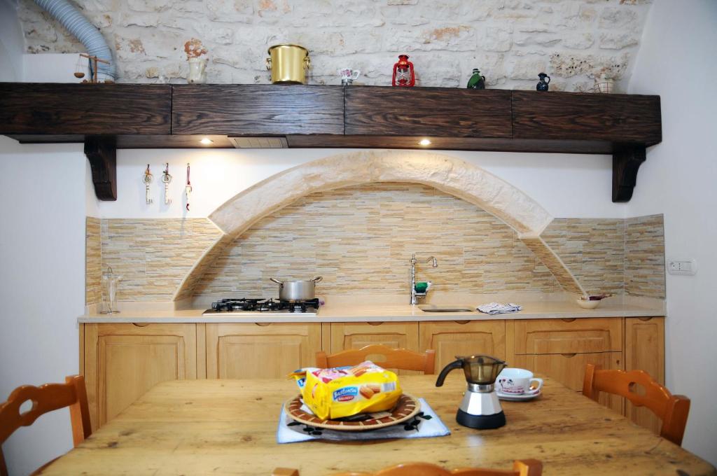 eine Küche mit einem Tisch und einem Kuchen darauf in der Unterkunft Casa del Carbonaio in Locorotondo