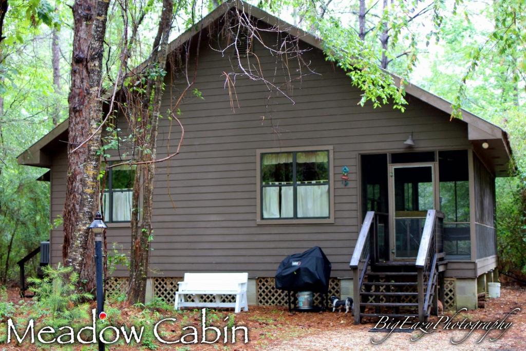 ein kleines Haus im Wald mit einer Veranda in der Unterkunft The Meadow Cabin in Folsom