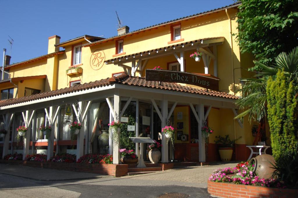 un bâtiment jaune avec un panneau indiquant la voie de conduite dans l'établissement Logis Hôtel Restaurant Chez Nous, à Sainte-Croix