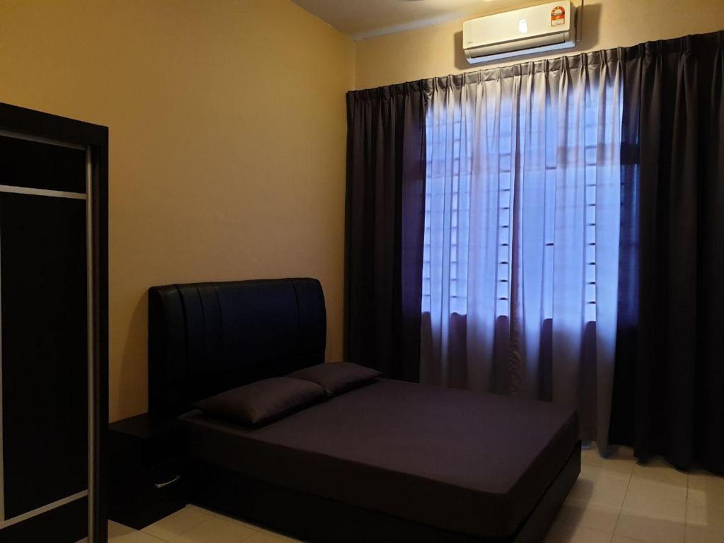 a bedroom with a bed and a window with curtains at LindaNazri Homestay MITC Melaka in Melaka