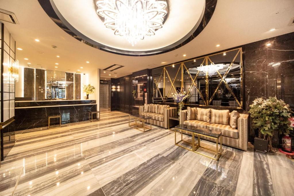 a lobby with couches and a chandelier at The Grandeur Hotel in Kawasaki