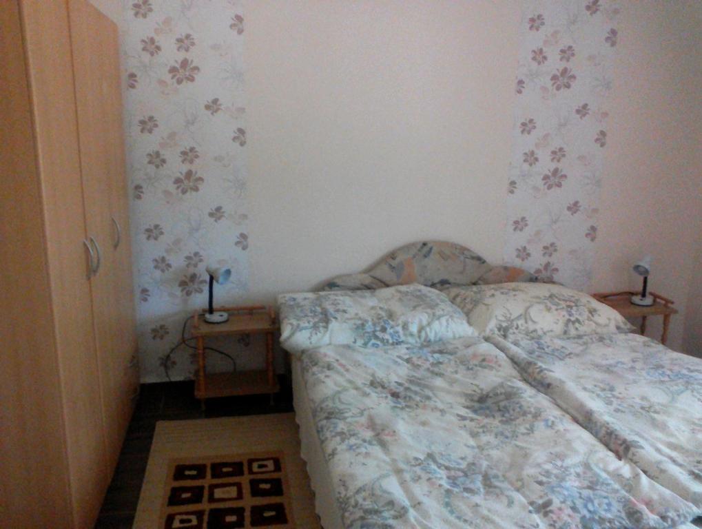 ハイドゥソボスローにあるRáday Apartmanの小さなベッドルーム(ベッド1台、ナイトスタンド2台付)