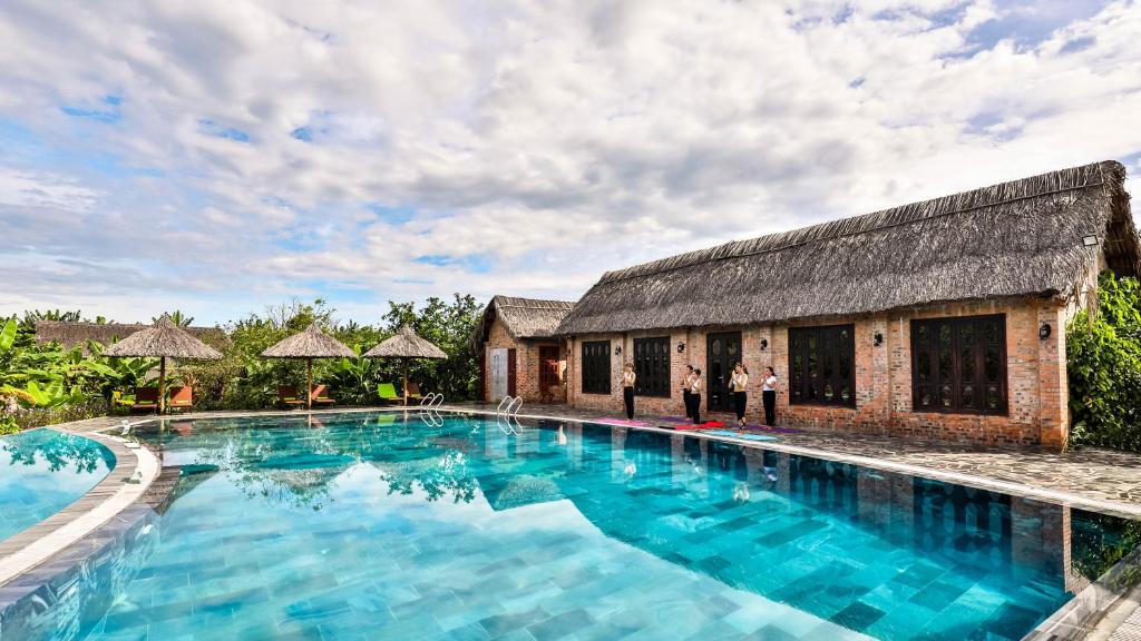 a large swimming pool in front of a building at Hue Ecolodge in Hue