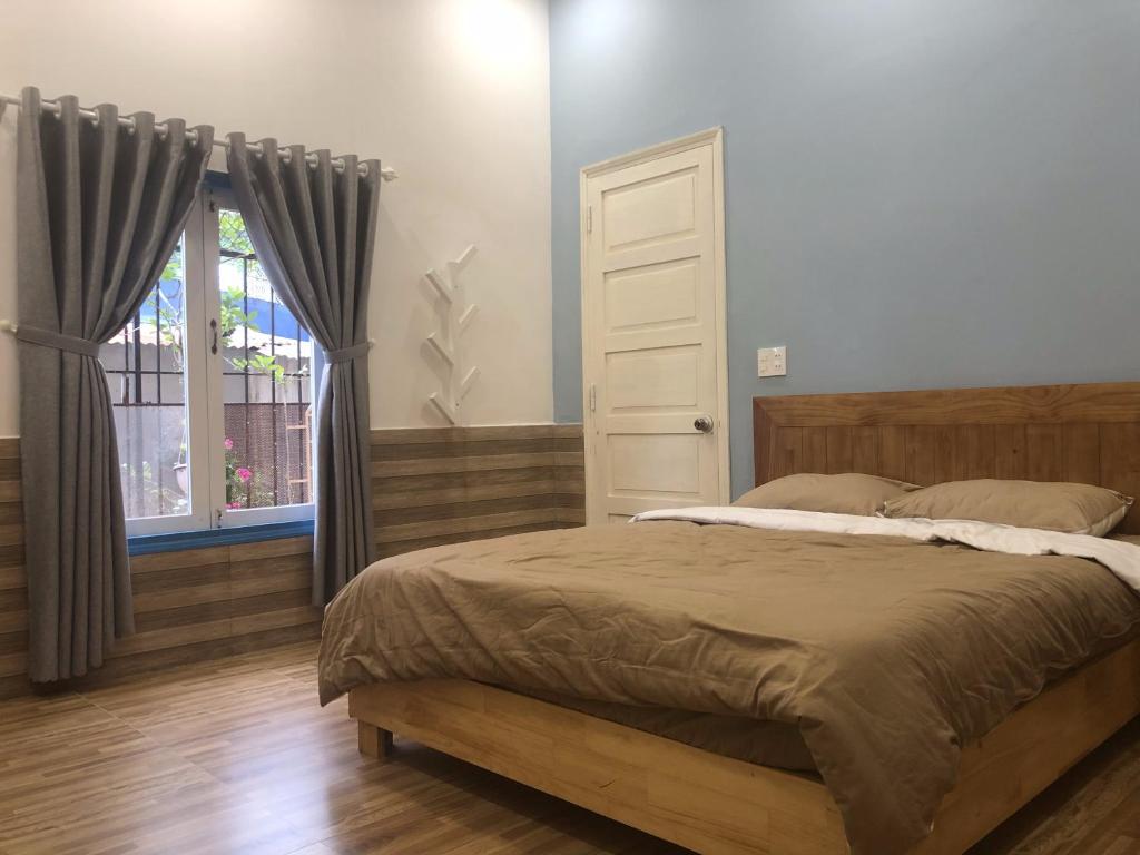a bedroom with a bed and a window at Ruby Dalat Hostel in Da Lat