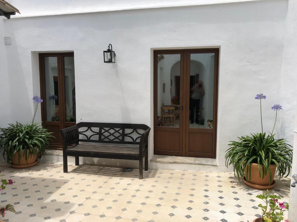 ベヘール・デ・ラ・フロンテーラにあるCasa Horizonte Africaの二本の植物を持つ戸前に座るベンチ