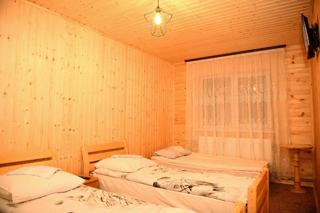 ミザヤリヤにあるГостинний двір Євгеніяのベッド2台と窓が備わる客室です。