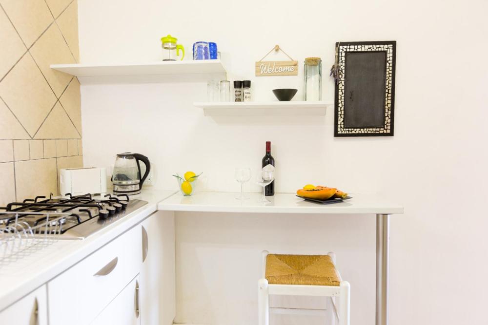 a white kitchen with a stove and a counter at Ocean Breeze Bloubergstrand in Bloubergstrand