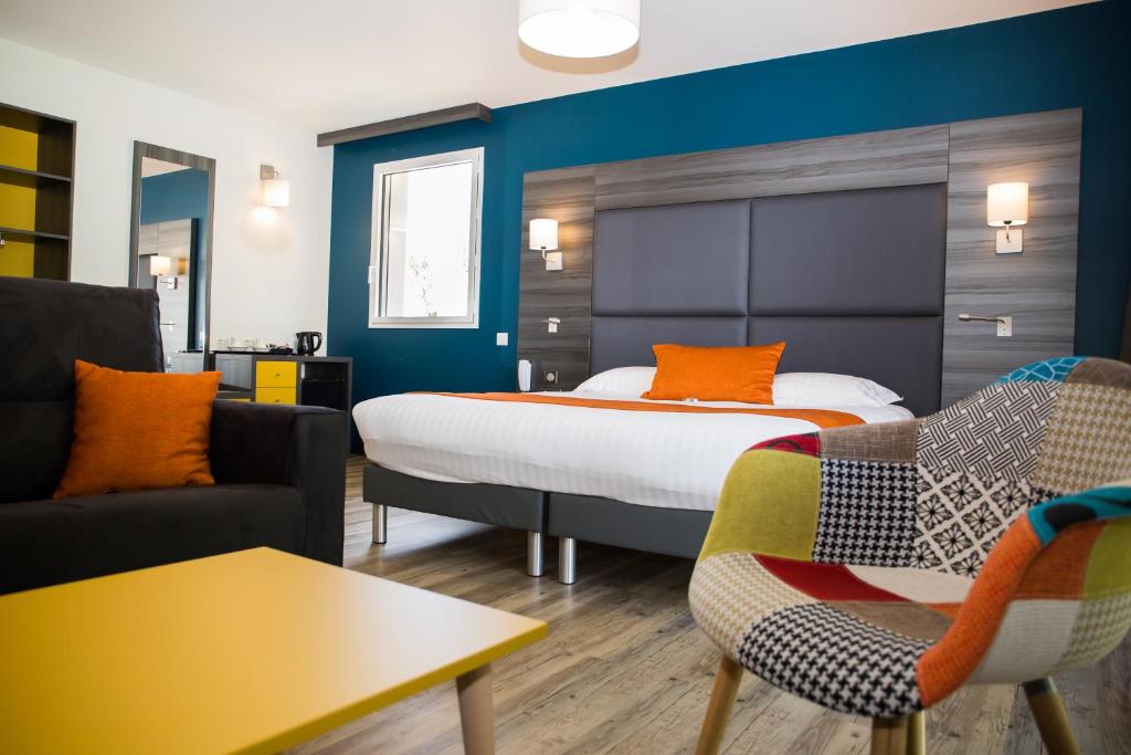 a hotel room with a bed and a couch at Le Domaine des Oliviers in Pierrelatte