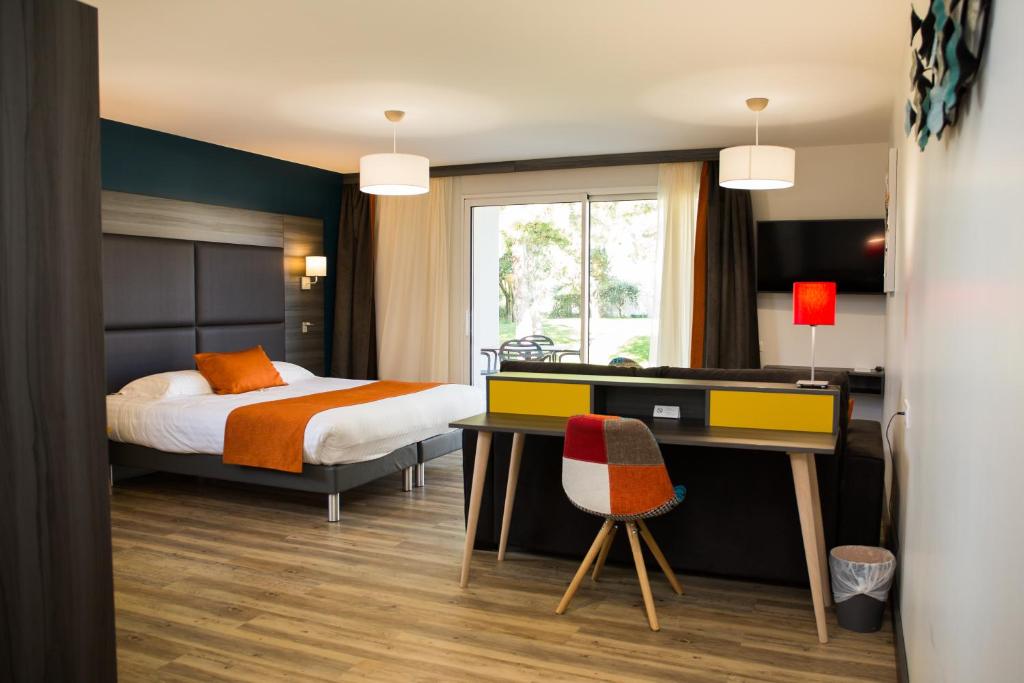 a bedroom with a bed and a desk with a desk at Le Domaine des Oliviers in Pierrelatte